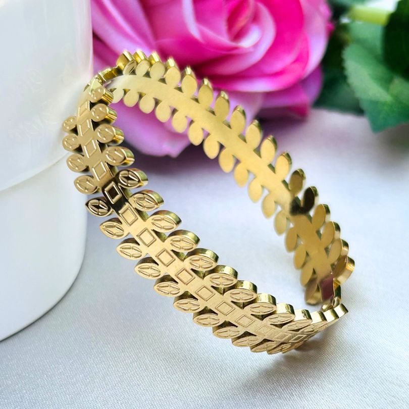wide, bold gold cuff with an intricate repeating leaf pattern | Tarnish-Free Gold-Tone Stainless Steel